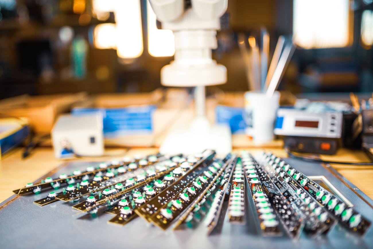 Ordinateur avec cartes de circuits imprimés vertes et noires utilisé dans un environnement industriel pour l’assemblage ou le contrôle électronique.